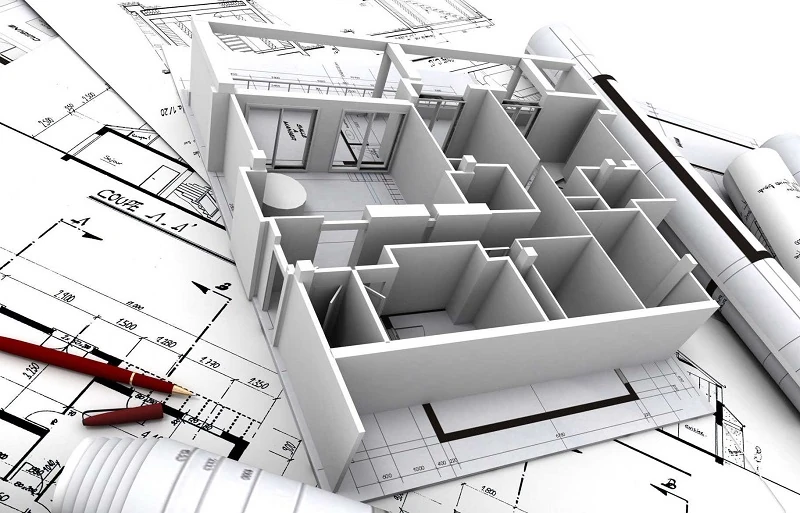 Maquette blanche de bâtiment posée sur des plans